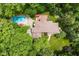 Aerial view of the home showcasing a swimming pool, deck, landscaped yard, and surrounding trees at 5977 S 800 E, Zionsville, IN 46077