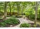 Picturesque backyard featuring stone pathways, a cozy seating area, and plenty of shade from mature trees at 5977 S 800 E, Zionsville, IN 46077