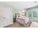 Cozy bedroom with ensuite, large window, carpeted floor, a queen-size bed, and white closet doors at 5977 S 800 E, Zionsville, IN 46077