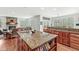 Open kitchen with an island, granite counters, wood cabinets, hardwood floors, and a view of the living room and fireplace at 5977 S 800 E, Zionsville, IN 46077