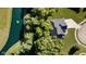 A bird's eye view of a home nestled near lush trees and a pond featuring a fountain with a sprawling driveway at 6208 W Foster Ridge Ln, Pendleton, IN 46064