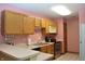 Charming kitchen with wooden cabinets, a stainless-steel stove, and bright pink walls at 6725 Bridgefield Way # 1, Indianapolis, IN 46254