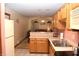 View of the kitchen leading to the living area, refrigerator, and wood cabinets at 6725 Bridgefield Way # 1, Indianapolis, IN 46254