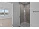 Modern bathroom featuring a glass-enclosed shower and neutral tile, complemented by an adjacent bedroom at 7070 Nine Penny Dr, Brownsburg, IN 46112