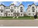 Modern white townhomes featuring black trim, covered entrances, and manicured front lawns at 7070 Nine Penny Dr, Brownsburg, IN 46112