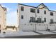 Modern townhome garages with balcony above, offering convenient parking with snow covered ground at 7070 Nine Penny Dr, Brownsburg, IN 46112