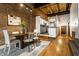 Dining room with exposed brick, hardwood floors, and kitchen access at 735 Lexington Ave # 1, Indianapolis, IN 46203