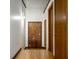 Hallway featuring hardwood floors, rustic wooden doors, and modern sconce lighting at 735 Lexington Ave # 1, Indianapolis, IN 46203