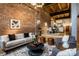 Living room features exposed brick wall, neutral furniture and decor, open floor plan to the kitchen and dining room at 735 Lexington Ave # 1, Indianapolis, IN 46203