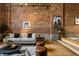 Bright living room features exposed brick wall, neutral sofa, and stylish decor with large windows at 735 Lexington Ave # 1, Indianapolis, IN 46203