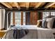 Bright bedroom with wood beams, brick accents, large windows, and a cozy bed at 735 Lexington Ave # 1, Indianapolis, IN 46203