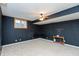 Spacious finished basement with chalkboard accent wall, fan, and carpet at 7472 Windridge Way, Brownsburg, IN 46112