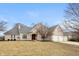 Charming brick home with a well-maintained lawn, mature trees, and a three-car garage at 7472 Windridge Way, Brownsburg, IN 46112