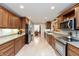 Well-lit kitchen featuring wood cabinetry, modern appliances, and a view into the dining area at 7472 Windridge Way, Brownsburg, IN 46112