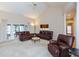 Bright living room featuring a high ceiling, comfortable leather furniture, and natural light at 7472 Windridge Way, Brownsburg, IN 46112