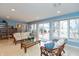 Cozy sunroom with bright blue walls, comfortable seating, and large windows overlooking the backyard at 7472 Windridge Way, Brownsburg, IN 46112