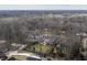 Large property enveloped by lush forest featuring many amenities, including a tennis court, mature trees, and ample green space at 8001 N Illinois St, Indianapolis, IN 46260