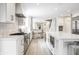 Bright, all-white kitchen with large island, stainless appliances, and seating for two at the breakfast bar at 8001 N Illinois St, Indianapolis, IN 46260