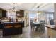 Open floor plan features kitchen with dark cabinets, large island, and dining table with backyard views at 8193 Cagles Mill Trce, Avon, IN 46123