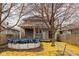 View of the backyard with above-ground pool, deck, and a gray two-story home with covered porch and a fenced-in yard at 825 N Bancroft St, Indianapolis, IN 46201