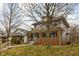 A charming two-story home features a welcoming front porch, complemented by nearby trees at 825 N Bancroft St, Indianapolis, IN 46201