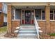 Inviting front porch with brick pillars, a secure entryway, and a classic design at 825 N Bancroft St, Indianapolis, IN 46201
