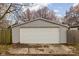 Detached two-car garage featuring light gray siding, white door, and a concrete driveway at 825 N Bancroft St, Indianapolis, IN 46201