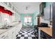 Charming kitchen with black and white floors, white cabinets, and modern appliances at 825 N Bancroft St, Indianapolis, IN 46201