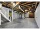 Unfinished basement with exposed utilities, concrete floor, and access to stairs at 959 E Bradbury Ave, Indianapolis, IN 46203
