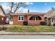 Charming brick home featuring a cozy front porch, complemented by manicured landscaping and a well-maintained lawn at 959 E Bradbury Ave, Indianapolis, IN 46203