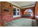 Inviting front porch with brick archway, swing and tile flooring, perfect for relaxing and enjoying the outdoors at 959 E Bradbury Ave, Indianapolis, IN 46203