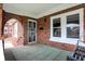 Welcoming front porch featuring a brick archway and tiled floors, offering a charming entrance to the home at 959 E Bradbury Ave, Indianapolis, IN 46203