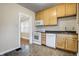 Efficient kitchen features white appliances and abundant cabinet space, with hardwood floors visible beyond the door at 959 E Bradbury Ave, Indianapolis, IN 46203