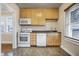 The kitchen features white appliances, neutral cabinets and flooring, and lots of natural light at 959 E Bradbury Ave, Indianapolis, IN 46203