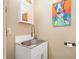 Small bathroom showcasing a sink with white cabinet and colorful artwork at 1020 E 51St St, Indianapolis, IN 46205