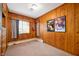 Comfortable bedroom with wood-paneled walls and a window, providing a cozy and bright space to relax in at 1020 E 51St St, Indianapolis, IN 46205