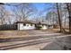 An updated one-story home featuring a long driveway surrounded by mature trees at 1020 E 51St St, Indianapolis, IN 46205