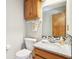 Cozy bathroom with granite countertop sink, wood cabinet, toilet, and towel rack at 10709 E County Road 100 N, Indianapolis, IN 46234
