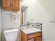 Clean bathroom with granite countertop sink, wood cabinet, toilet, and decorative backsplash at 10709 E County Road 100 N, Indianapolis, IN 46234