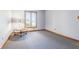 Well lit bedroom with grey carpet, small table and lamp, and window at 10709 E County Road 100 N, Indianapolis, IN 46234