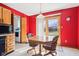 Cozy dining area featuring red walls, a wooden table with chairs, and a door leading to the outdoors at 10709 E County Road 100 N, Indianapolis, IN 46234
