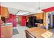 Eat-in kitchen with a table set for two, wood cabinets, and black appliances set against red walls at 10709 E County Road 100 N, Indianapolis, IN 46234