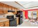 Charming eat-in kitchen featuring wood cabinets, black appliances, and a table set for two at 10709 E County Road 100 N, Indianapolis, IN 46234