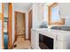 Well-lit laundry room featuring a washer, dryer, cabinets, and a window for natural light at 10709 E County Road 100 N, Indianapolis, IN 46234