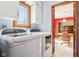 Bright laundry room with a washer, dryer, overhead cabinets, and open doorway to another room at 10709 E County Road 100 N, Indianapolis, IN 46234