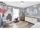 Playful bedroom with whimsical wall decor, wood floors, and plenty of space for activities at 10896 Fairwoods Dr, Fishers, IN 46037