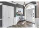 Bright foyer featuring wood floors, statement doors, neutral walls, and wainscoting, creating an open and welcoming entrance at 10896 Fairwoods Dr, Fishers, IN 46037
