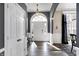 Inviting foyer with wood floors, neutral walls, wainscoting, and a statement chandelier hanging above the front door at 10896 Fairwoods Dr, Fishers, IN 46037