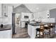 Bright kitchen boasts white cabinetry, dark countertops, stainless steel appliances, and an island with seating at 10896 Fairwoods Dr, Fishers, IN 46037