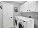 Functional laundry room with modern appliances, white cabinets, and neutral walls and floors at 10896 Fairwoods Dr, Fishers, IN 46037